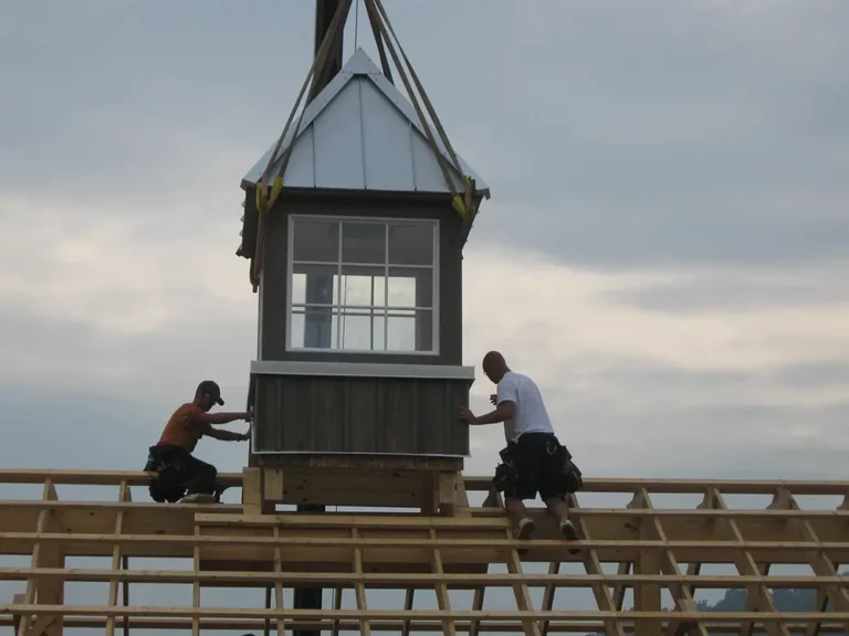 workmen securing the cupola to the roof